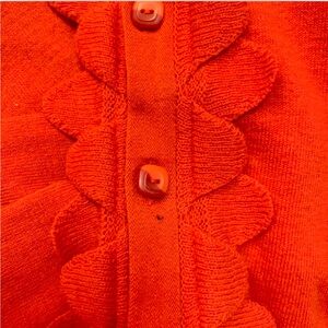 Adorable S/M red orange cardigan with delicate ruffles and square buttons.